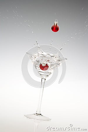 A Holiday martini with a falling red bauble. Stock Photo