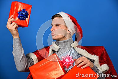 Holiday presents concept. Man looks at red xmas gift box. Stock Photo