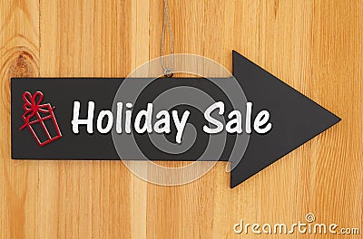 Holiday Sale type message on hanging arrow chalkboard sign with a red present Stock Photo