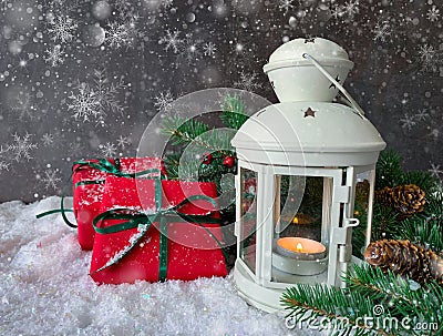 Holiday shiny christmas composition. Burning candle lamp with red gifts, pine cone, berries and fir tree. Stock Photo
