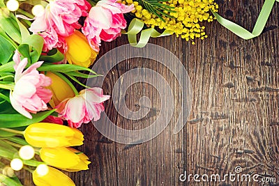 Holiday spring background. Mother`s Day holiday wooden backdrop frame decorated with colorful tulip flowers and mimosa flower Stock Photo