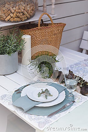 Holiday Summer or early autumn outside table setting with linen napkins and green leaves. Close up Stock Photo