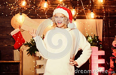 Holiday time. woman in santa hat. woman hold parcel. write wish list. letter to santa. family greeting with holidays Stock Photo