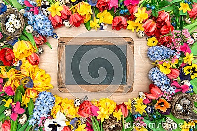 Holidays background with chalkboard. Spring flowers and easter e Stock Photo