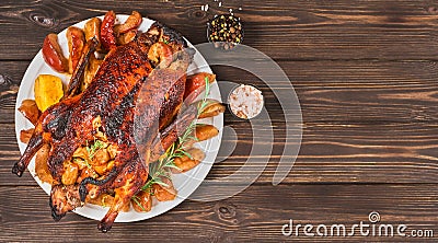 Holidays baked farm duck with apples, quince and spices on a dark vintage table.Top view with copy space of a baked duck for Stock Photo