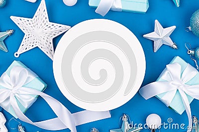 Holidays gift box wrapped in blue paper, balls, glitter on blue background Stock Photo