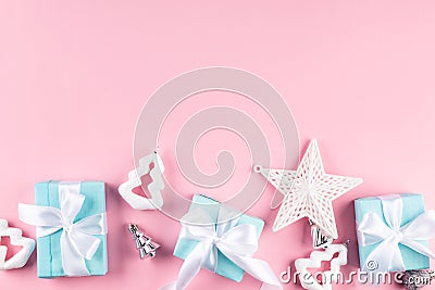 Holidays gift box wrapped in blue paper, balls, glitter on pink background Stock Photo