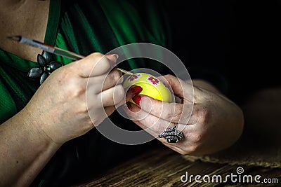 Holidays, traditional concept - close up of woman hands coloring Easter eggs with brush. Preparation for Easter. Close-up Stock Photo