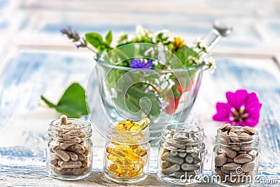 Holistic medicine approach. Healthy food eating, dietary supplements, healing herbs and flowers. wooden background, c. Stock Photo