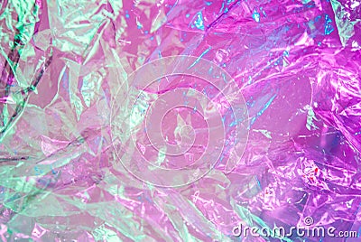 Holographic background in the style of the 80-90s. Real texture of cellophane film in bright acid colors. Stock Photo