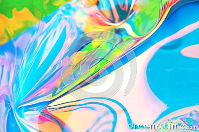 Holographic iridescent surface. Copy space. Bright colorful hologram background. Wrinkled abstract texture with multiple colors. Stock Photo