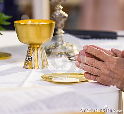 The hands of the Pope consecrate the host, the holy bread in the Stock Photo
