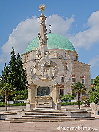 Holy triniti statue and Mosque of Pasha Qasim, Pecs Editorial Stock Photo