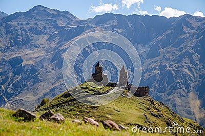 Holy Trinity Church in Kazbegi mountain range near Stepantsminda view Caucasus mountains in the background Stock Photo