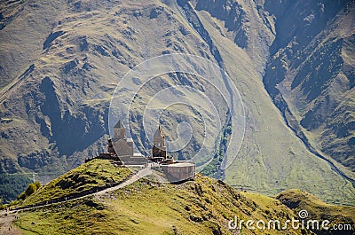 Holy Trinity Church in Kazbegi mountain range near Stepantsminda view Caucasus mountains in the background Stock Photo