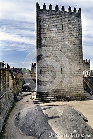 Homage tower of the castle of King Afonso Henriques of Portugal built in the eleventh century and bridge of union with the walls. Editorial Stock Photo