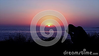 Hombre que ruega por el mar en la puesta del sol Hombre que ruega por el mar en la puesta del sol