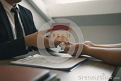 Home agents are giving house gifts to new home buyers in office room Stock Photo