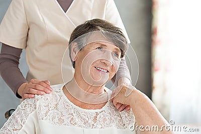 Assistant supporting smiling old lady Stock Photo
