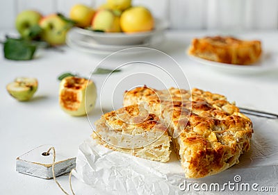 Home baked apple pie served on cutting board, yellow apples on white background, closeup view Stock Photo