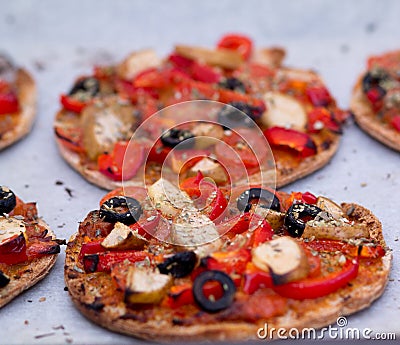 Home baked vegan mini pizza on parchment paper Stock Photo