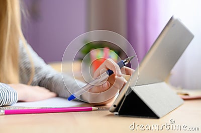 Children`s hand controls the tablet. Blurred background. Stock Photo