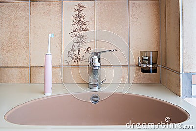 Home bathroom sink and electric toothbrush. Close up shot, no people Stock Photo