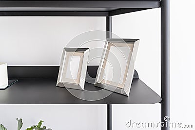 Home decoration, empty silver small portrait frames, blank canvas, picture mock up, living room shelf Stock Photo