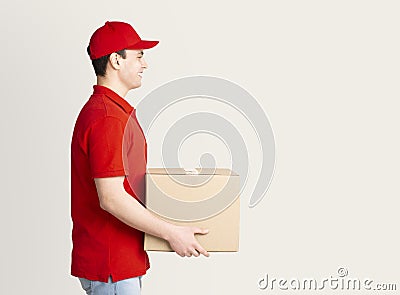 Home delivery. Courier in uniform delivers parcel to door. Stock Photo