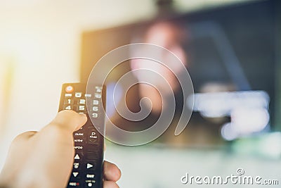 Home entertainment. hand hold Smart TV remote control with a television blur background Stock Photo