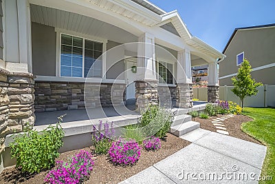 Home facade with plants flowers and pathway on the yard in front of the poch Stock Photo