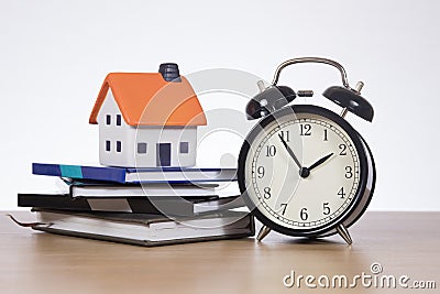 Home finance concept with ticking clock and books Stock Photo