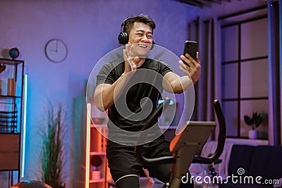 Home fitness workout sporty man training on smart stationary bike indoors. Stock Photo