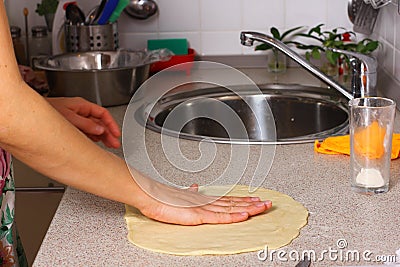 Making pizza by female hands on kitchen table. Stock Photo