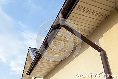 Home Guttering, Gutters, Plastic Guttering System, Guttering & Drainage Pipe Exterior against blue sky. Stock Photo