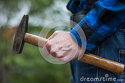 Home handyman: Rear view of a young man with hammer in his hand Stock Photo