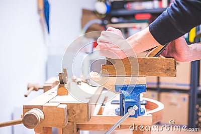 Home handyman using a plane for smoothing down a piece of timber Stock Photo