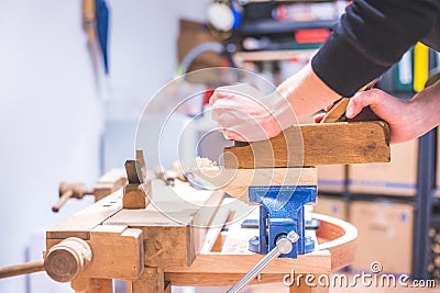 Home handyman using a plane for smoothing down a piece of timber Stock Photo