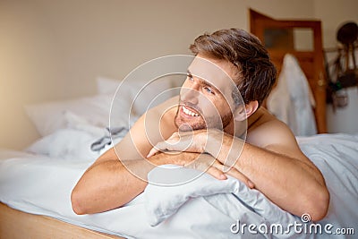 Home, house and happy relax man in bedroom, bed thinking and relaxing with a smile in the morning. Portrait of resting Stock Photo