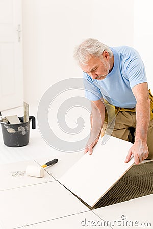 Home improvement - handyman laying ceramic tile Stock Photo