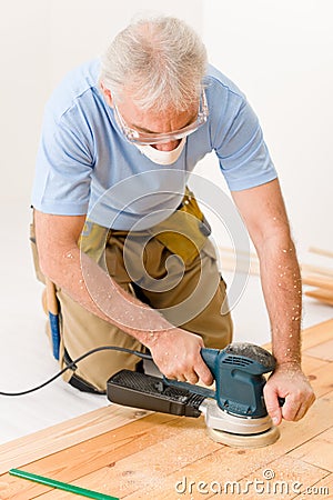 Home improvement - handyman sanding wooden floor Stock Photo