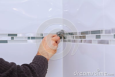 Applying silicone sealant with construction worker fills seam the ceramic tiles on the wall bathroom Stock Photo