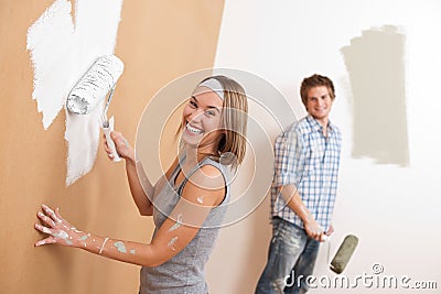 Home improvement: Young couple painting wall Stock Photo