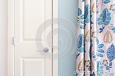 Home interior showing colonial closet door with blue curtain decor and light blue painted wall Stock Photo