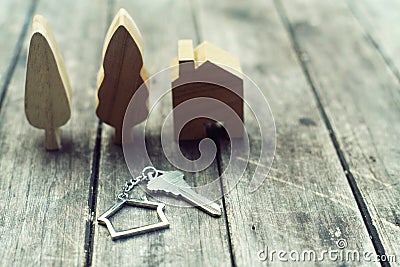 Home key with house keychain and wooden tree and home mockup on vintage wood background, property concept Stock Photo