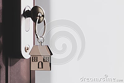 The home key with house keyring in the door keyhole with copy space Stock Photo