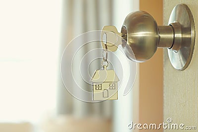 Home key with house keychain in keyhole, property concept Stock Photo