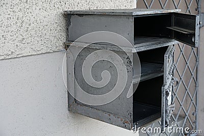 A home letterbox, mailbox or post-box with three compartments made of grey metal Stock Photo