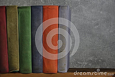 Home library of old battered retro books with colored spines. Stock Photo