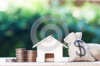 Home loan, mortgages, debt, savings money for home buying concept : US dollar in a money bag, small residential, house model on Stock Photo